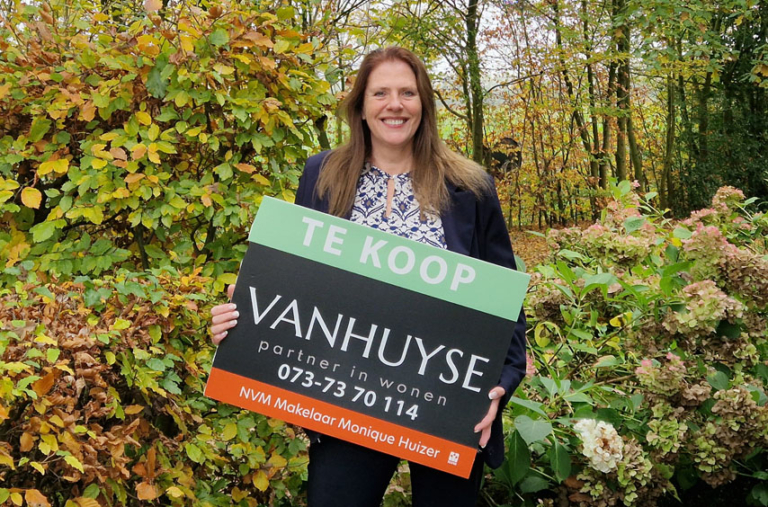 Makelaar Monique Huizer met een verkoopbord